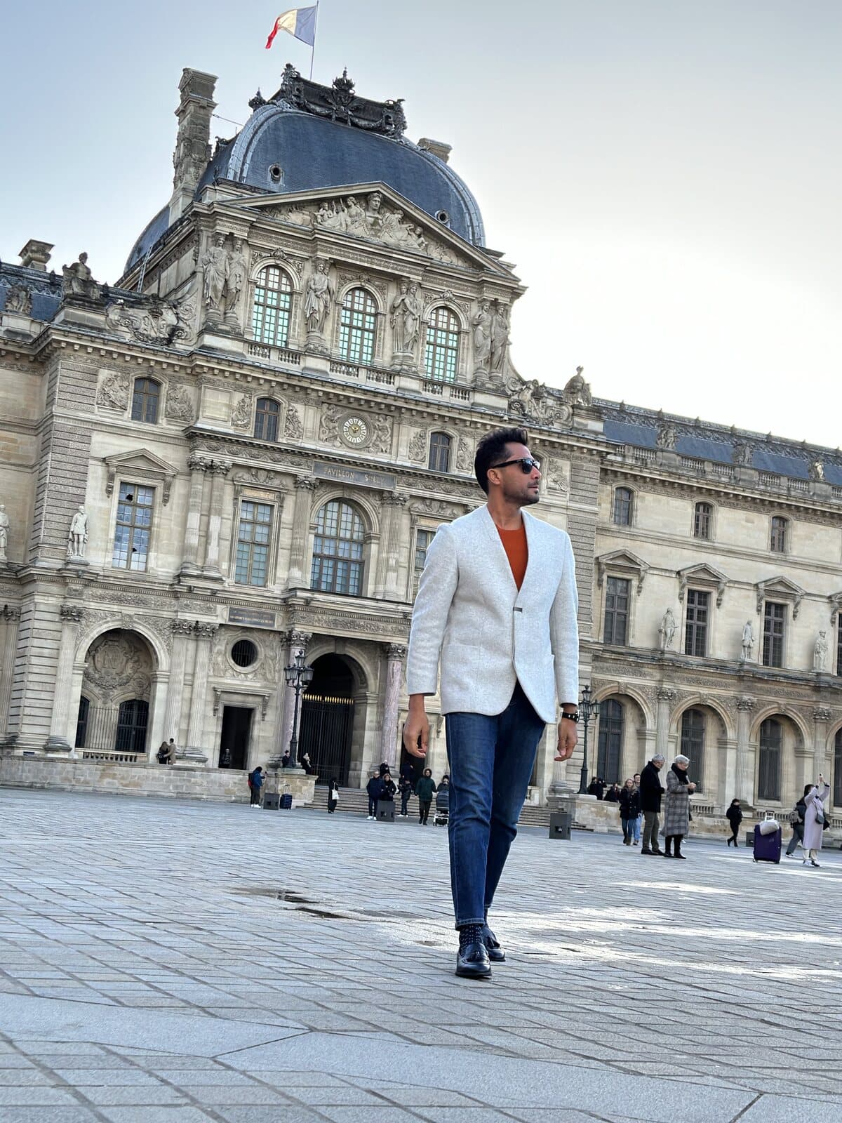 Ehsan Kaykhah walking across the Cour Napoléon in front of the Louvre, Paris