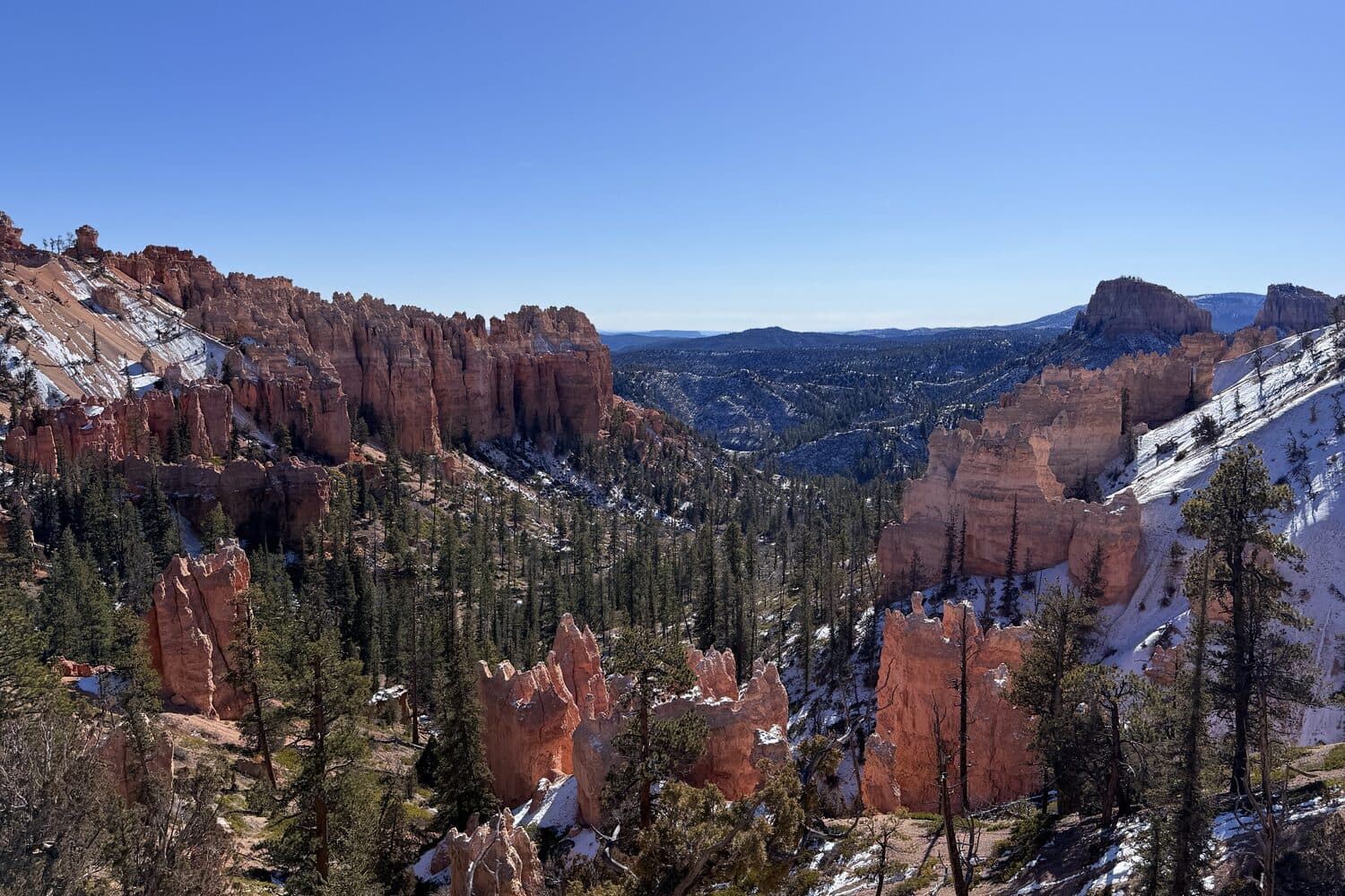 Snow still lying between the hoodoos of the amphitheatre in low winter sun, Bryce Canyon, Utah