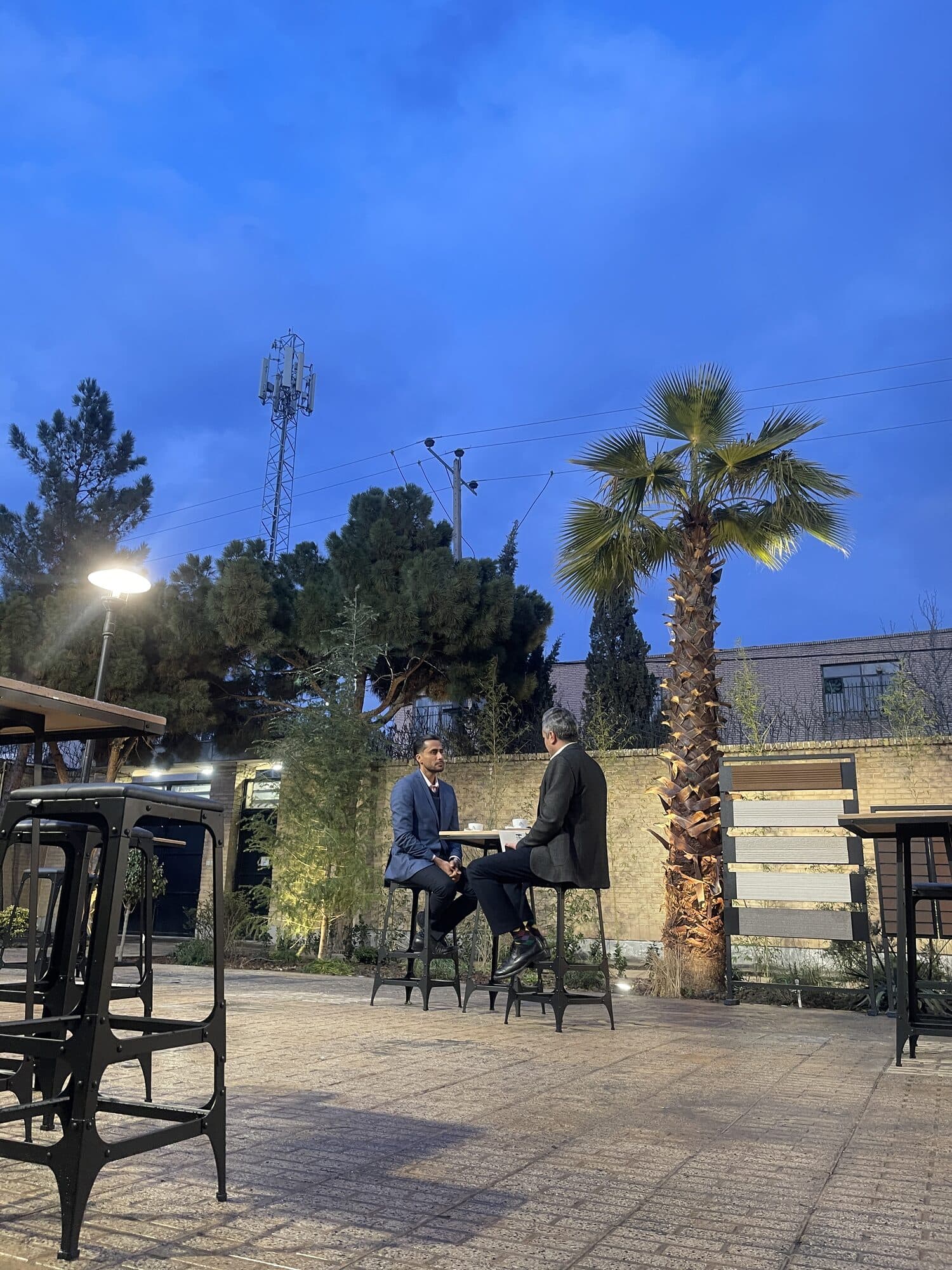 Three men talking beside the garden wall between sessions