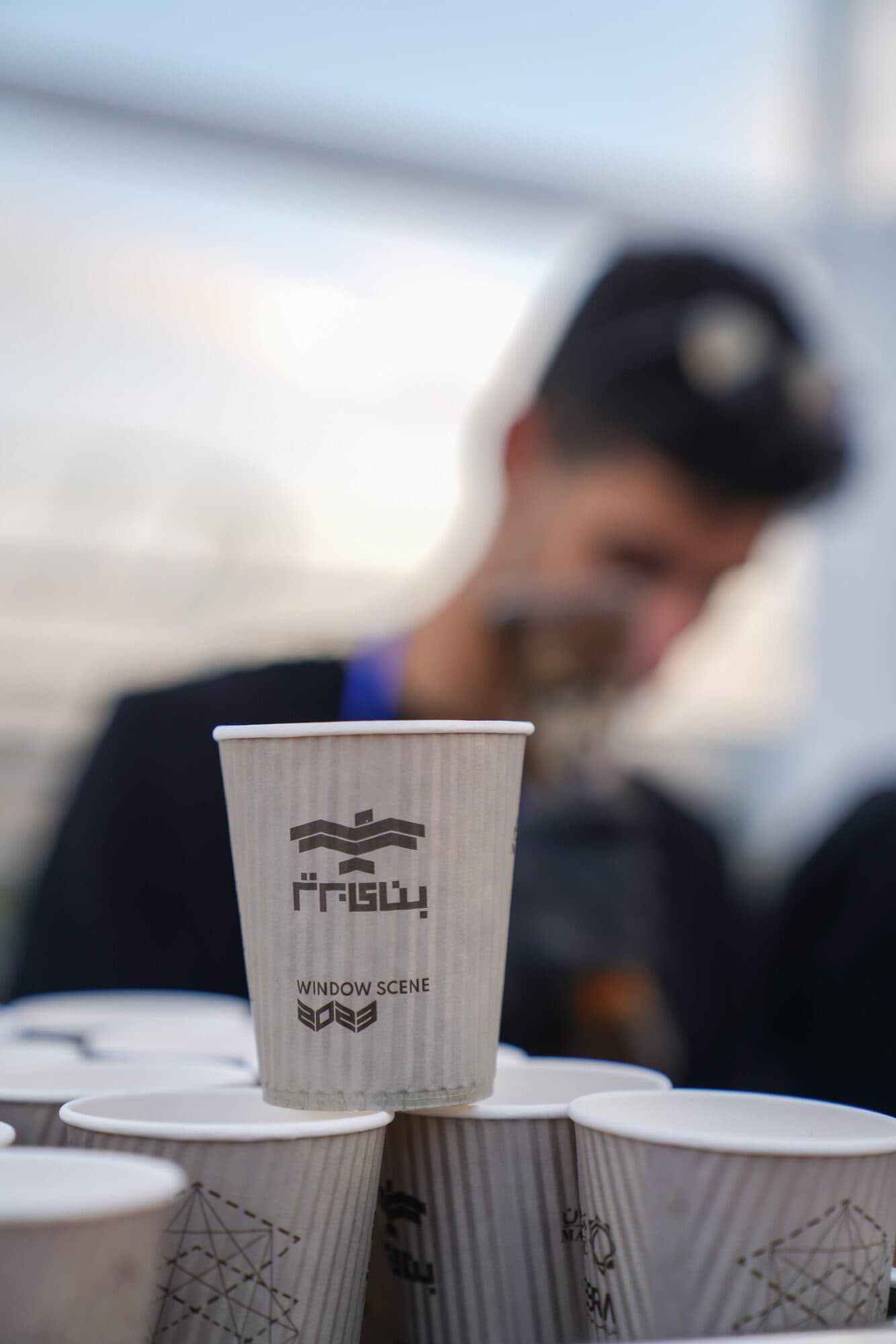 A stack of cups carrying the Banaye Bartar mark on the counter of the edition's café
