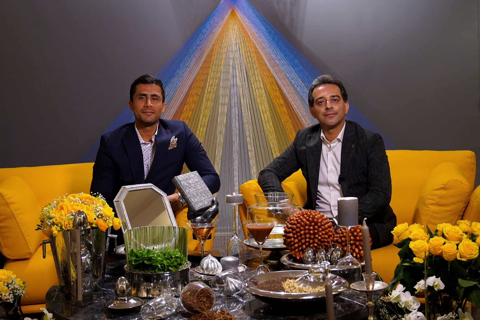Two guests seated together on the sofa behind the Haft-Seen, on one of thirty consecutive evenings.