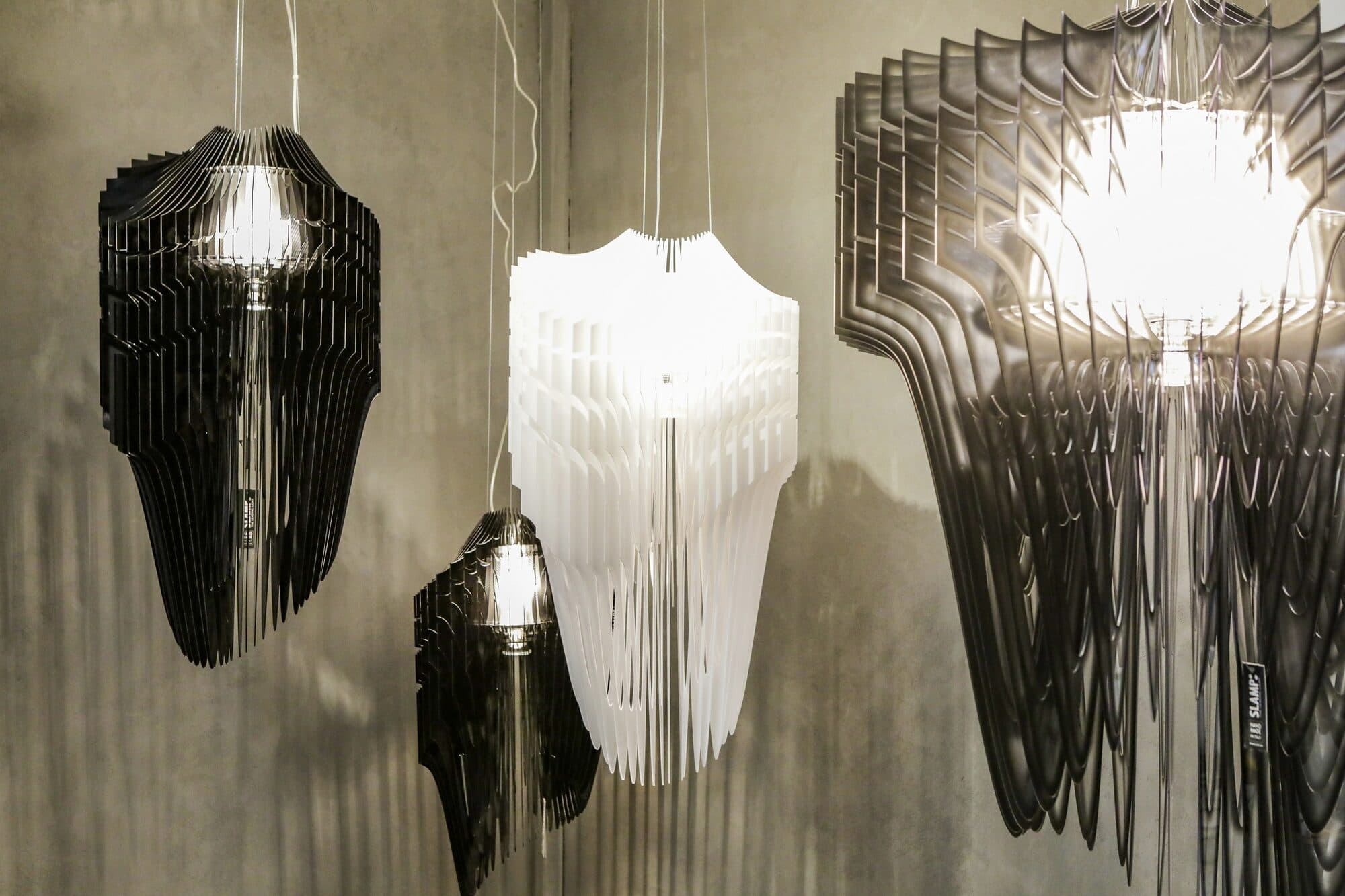 Two chandeliers hung side by side, one in black chain and one in clear glass