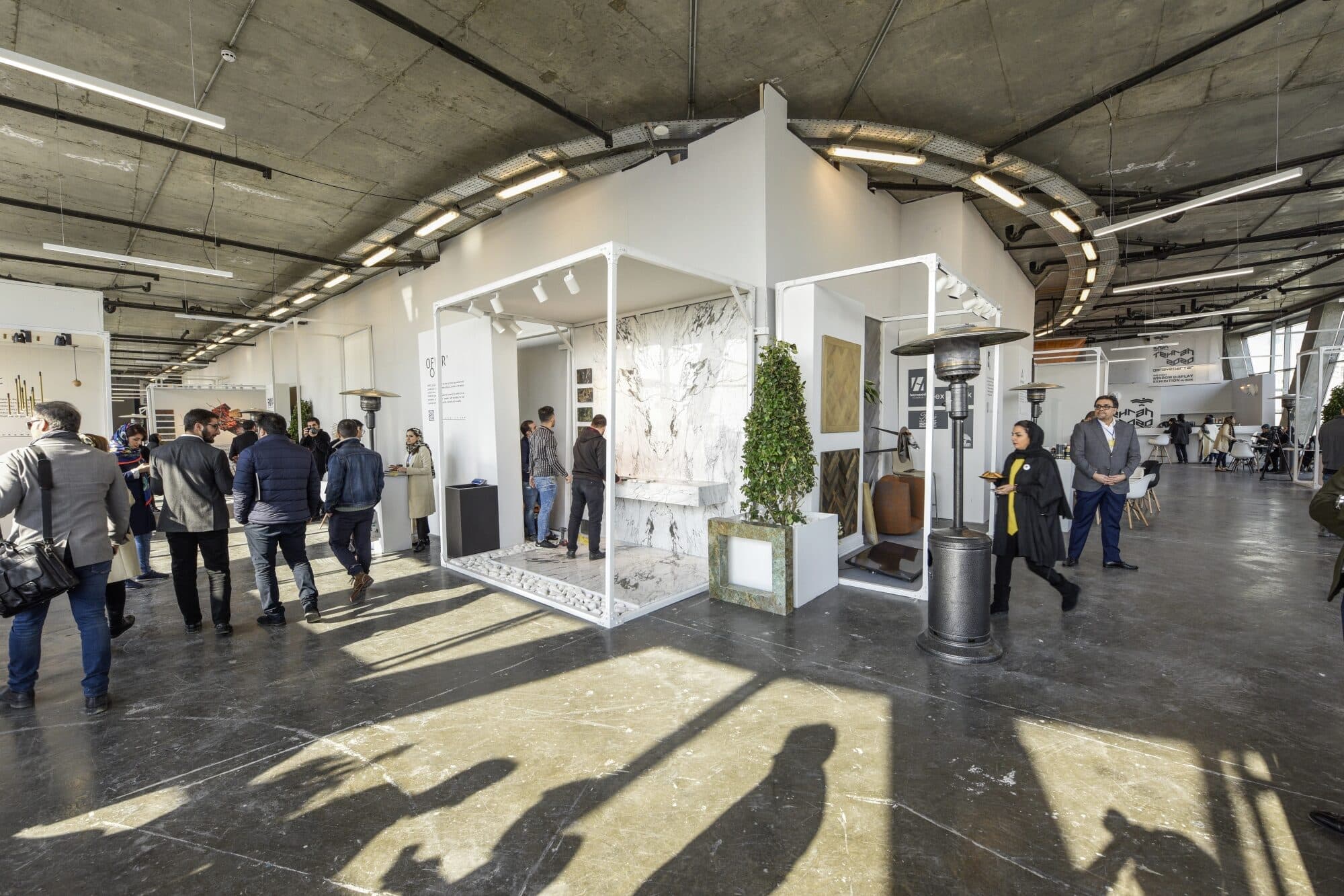 The floor with the exhibition running, long shadows across the concrete
