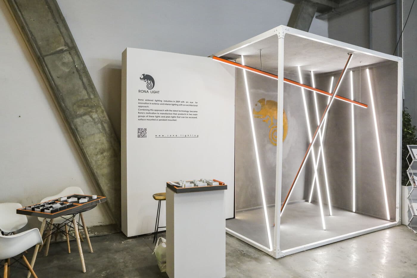 A white frame lit from within by vertical light lines, crossed by a single orange bar