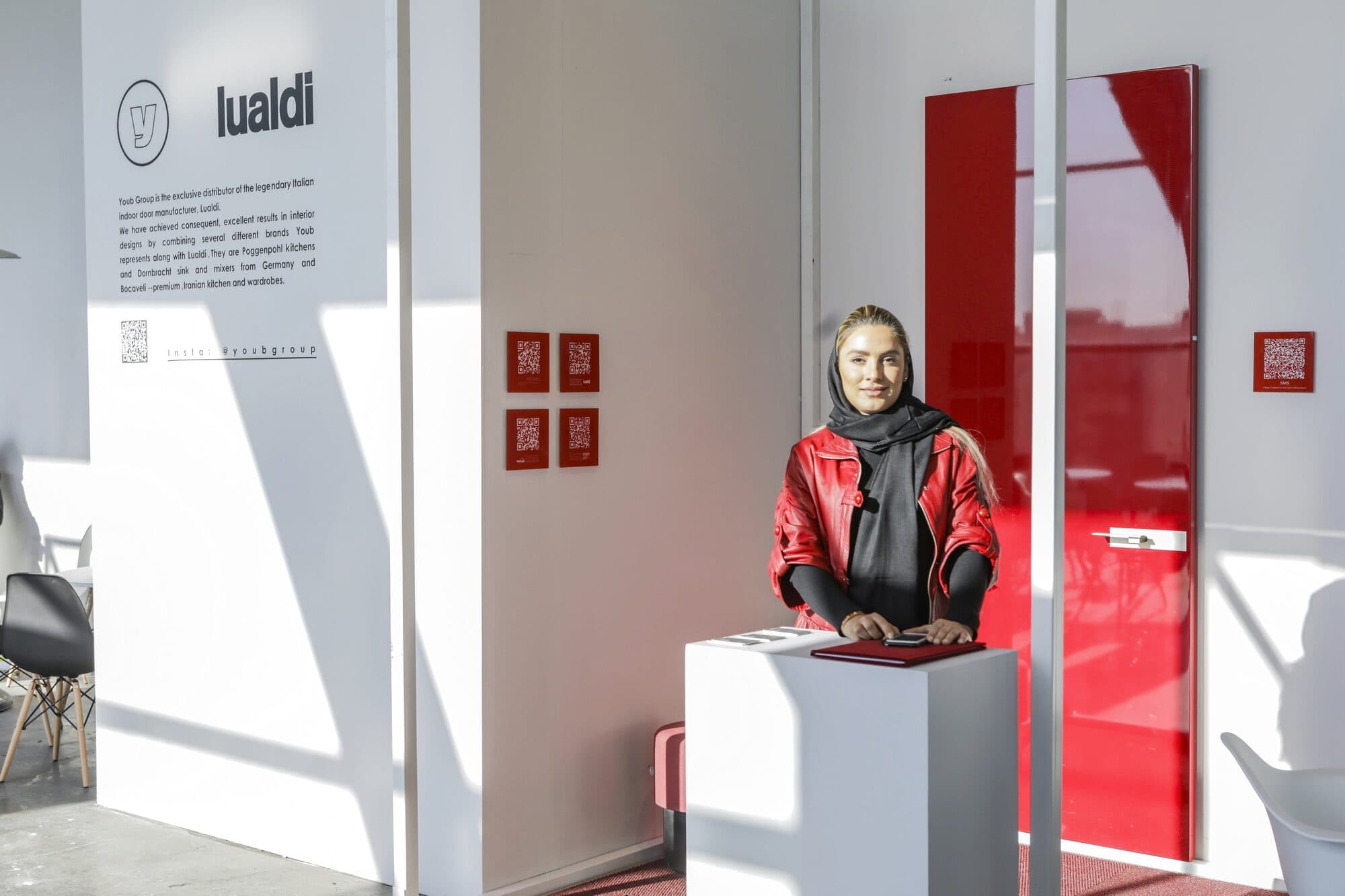 A red and white setting behind glass, a single visitor standing inside the frame