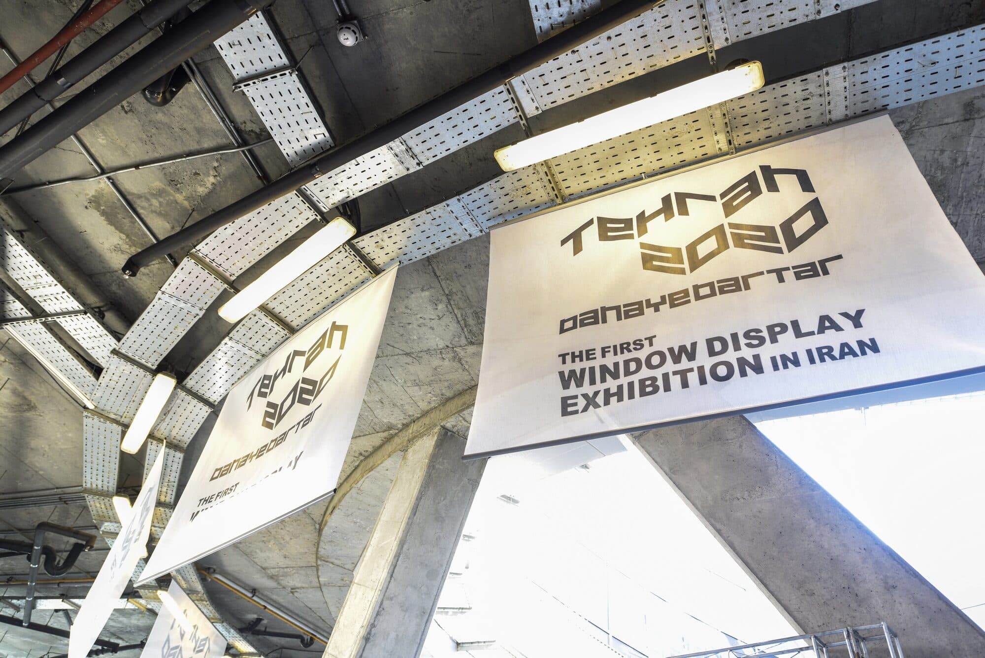 Signage under the entrance soffit reading THE FIRST WINDOW DISPLAY EXHIBITION IN IRAN, with the TEHRAN 2020 mark