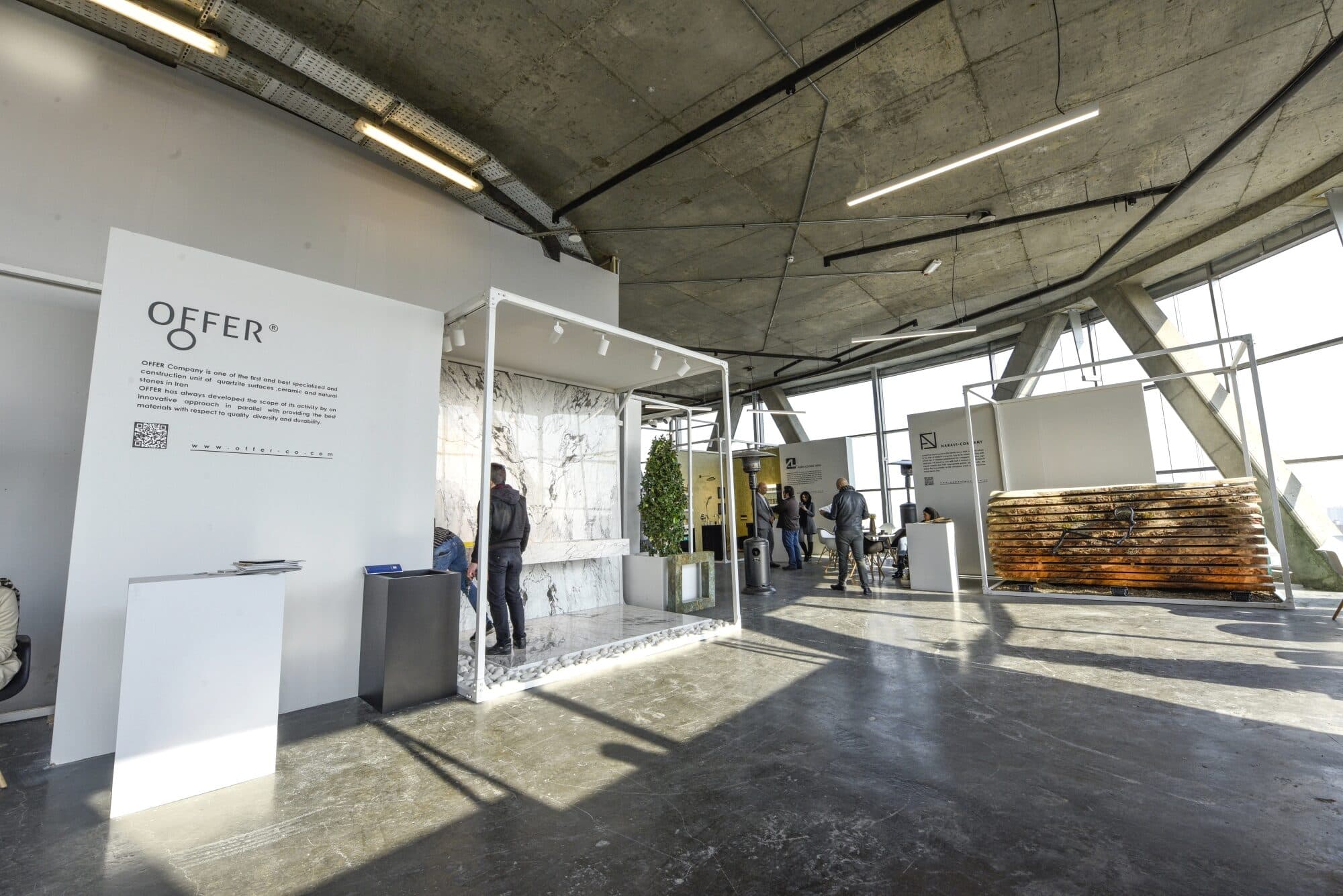 White display frames standing free on the concrete floor, each brand inside the same structure