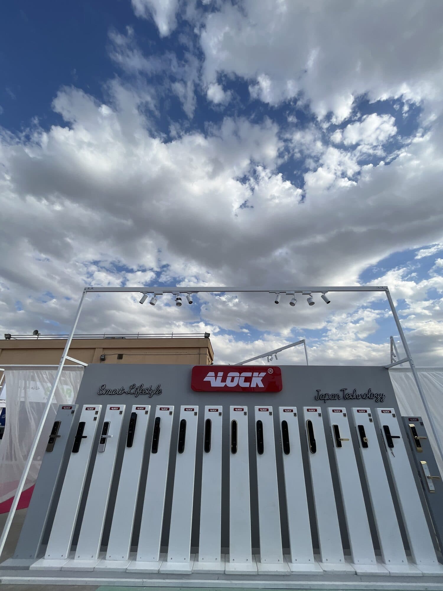 A wall of door hardware set out in a row on a white stand against the sky