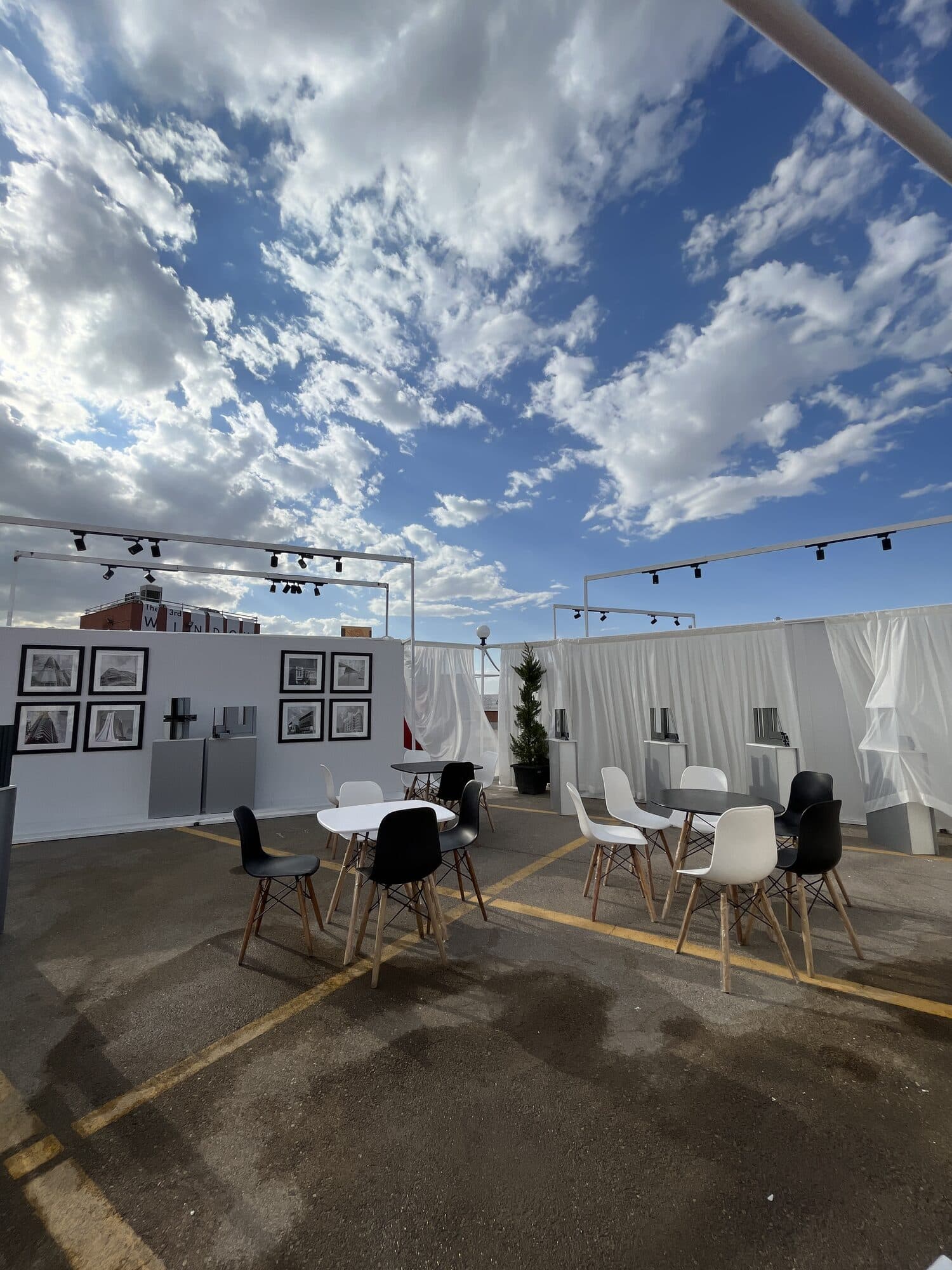 A stand hung as a picture gallery, seating in the middle of it and cloud overhead
