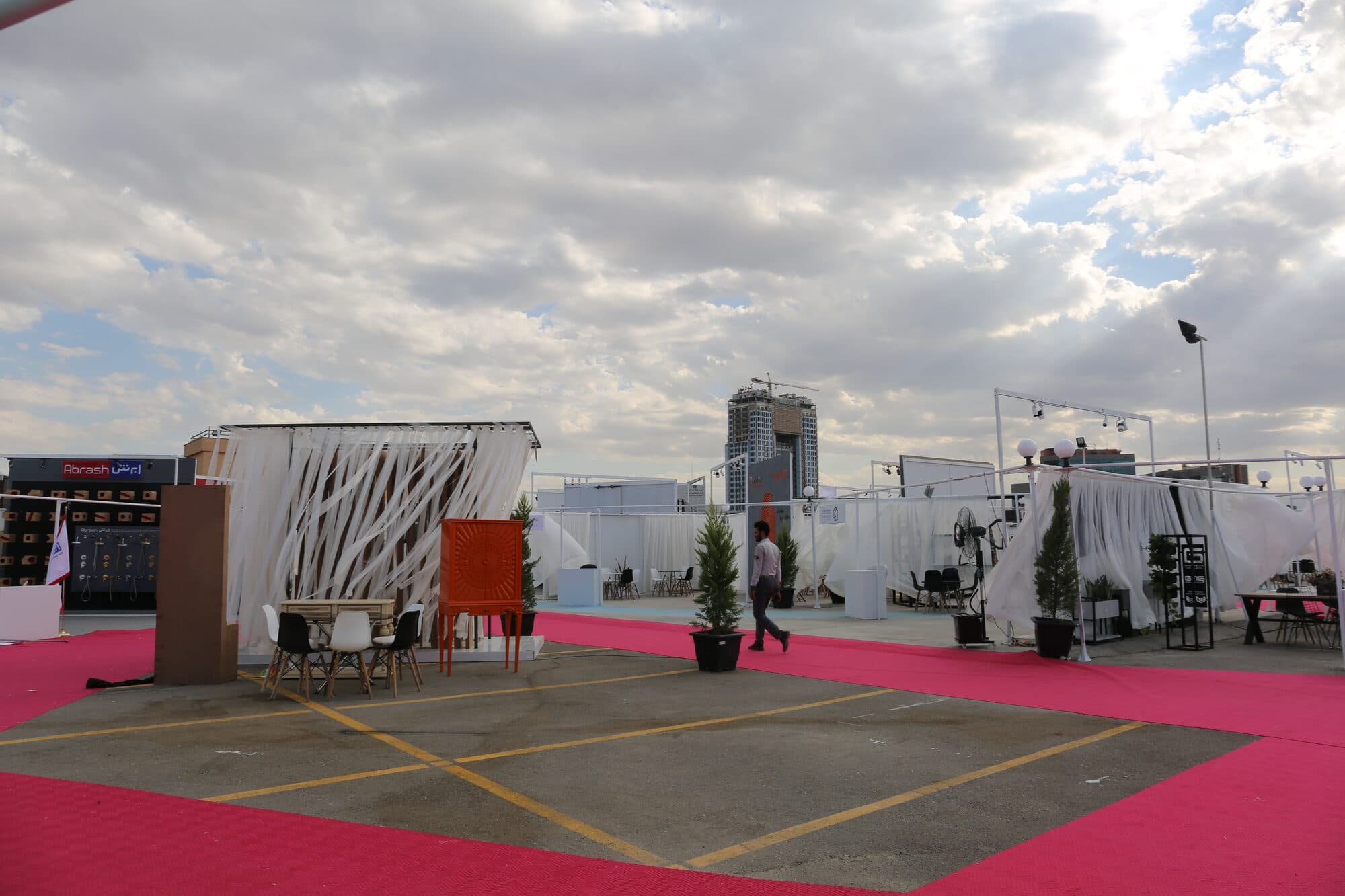 The open deck set and empty before the doors: red ground, white stands, the city behind