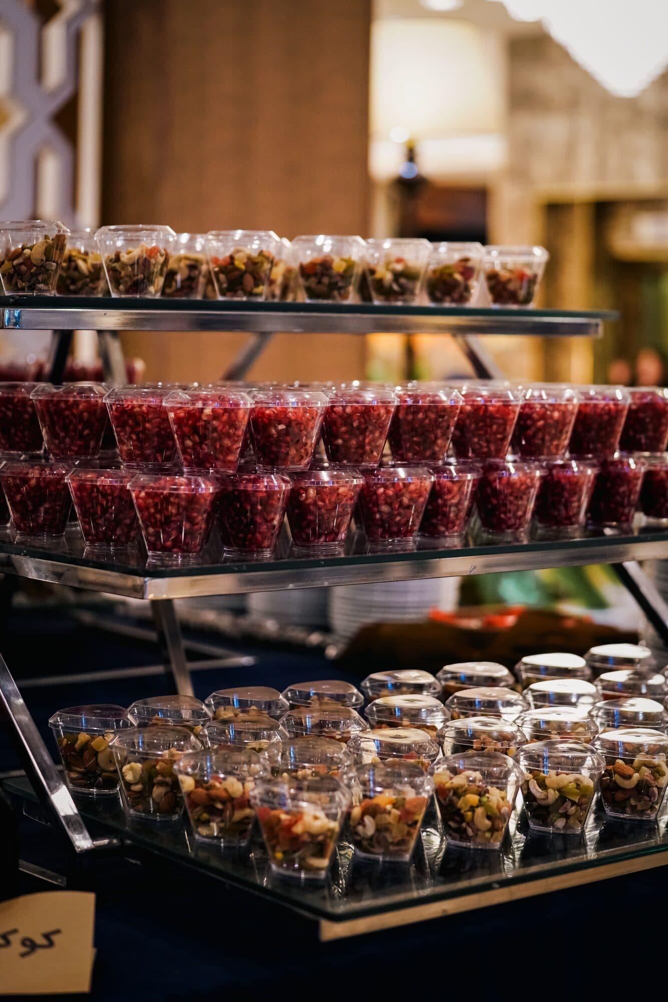 The Yalda table on tiered stands — pomegranate seeds in glasses, nuts and dried fruit in jars