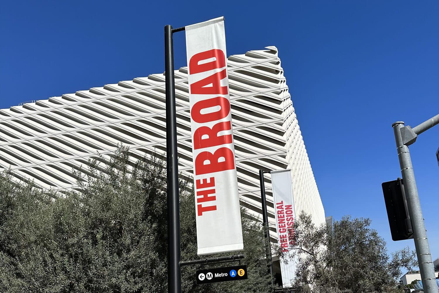 The museum's banner on the street, the veil of the building rising behind it
