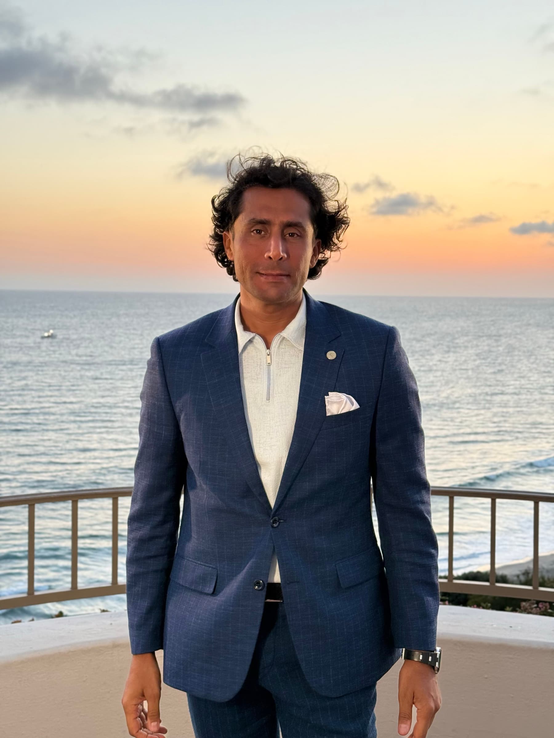 Ehsan Kaykhah standing on a terrace above the Pacific at sunset, Southern California