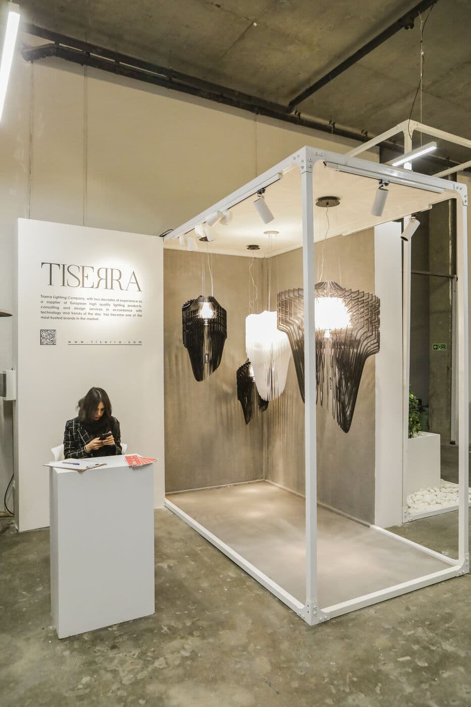 The TISERRA setting: dark woven pieces hung inside a white frame — WINDOW DISPLAY, Tehran 2020