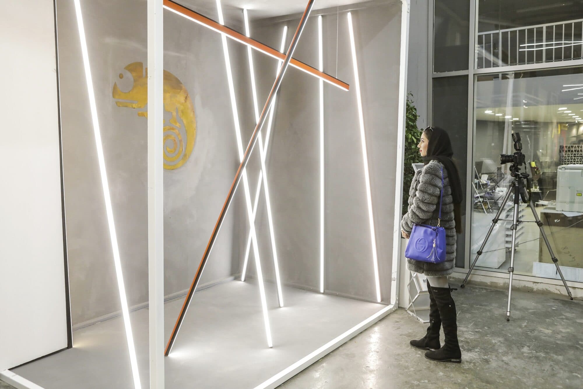 Lit display frames at WINDOW DISPLAY Tehran, with visitors walking the route between them