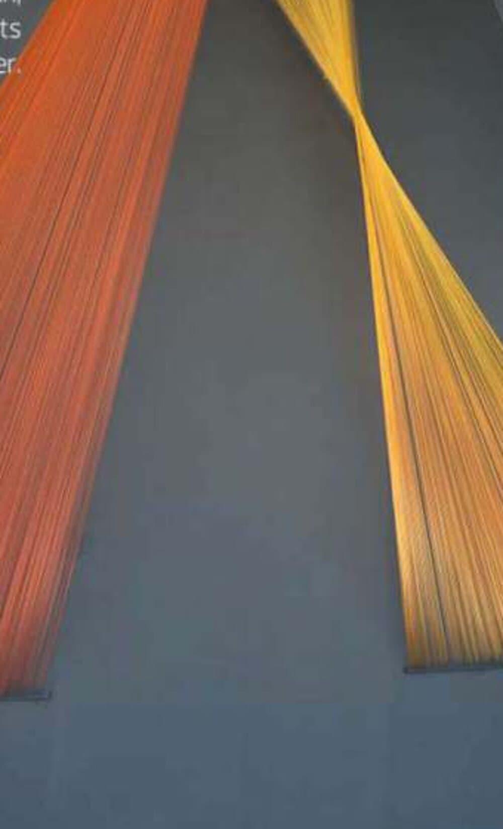Suspended orange and gold thread installation forming a light cone